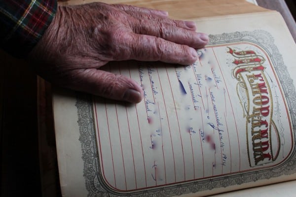 Dad rests hand on page with his name, names obscured